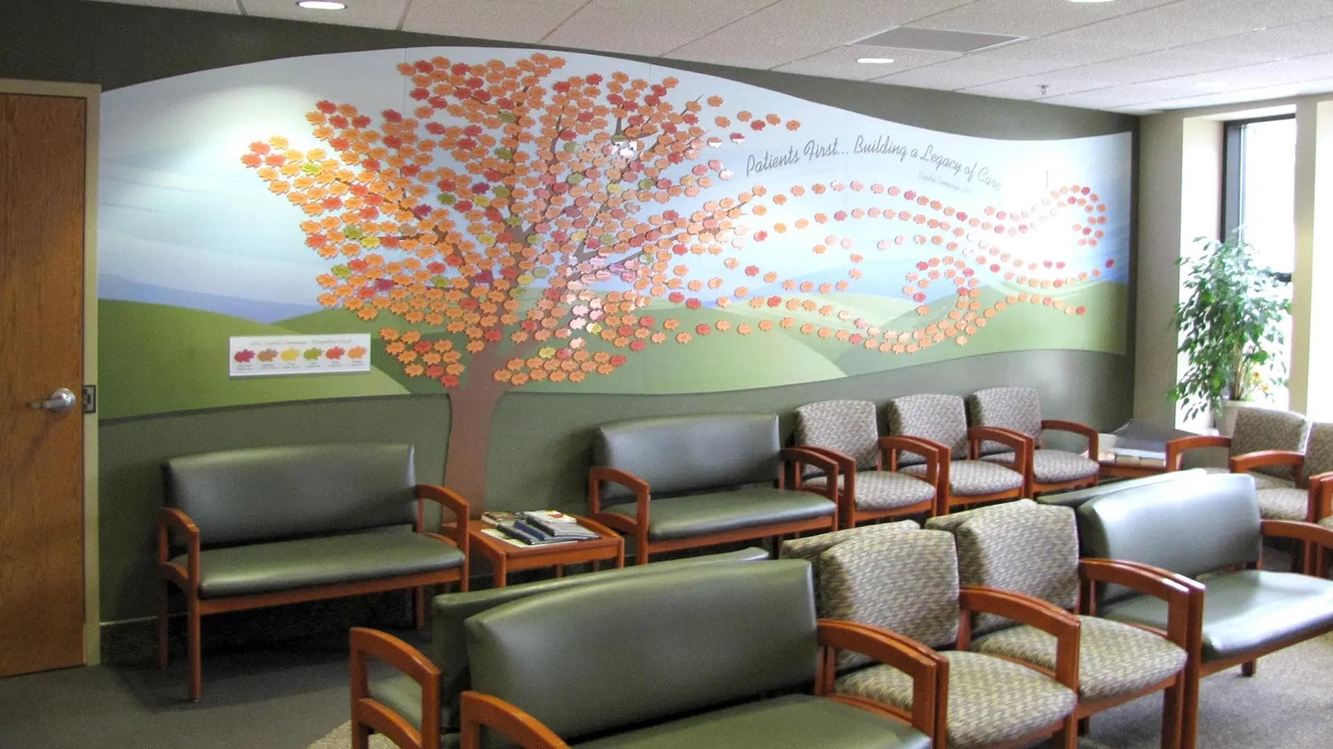 Palmer Lutheran donor tree leaf wall featuring individual donor leaves on a custom printed nature-inspired background in a healthcare waiting area.