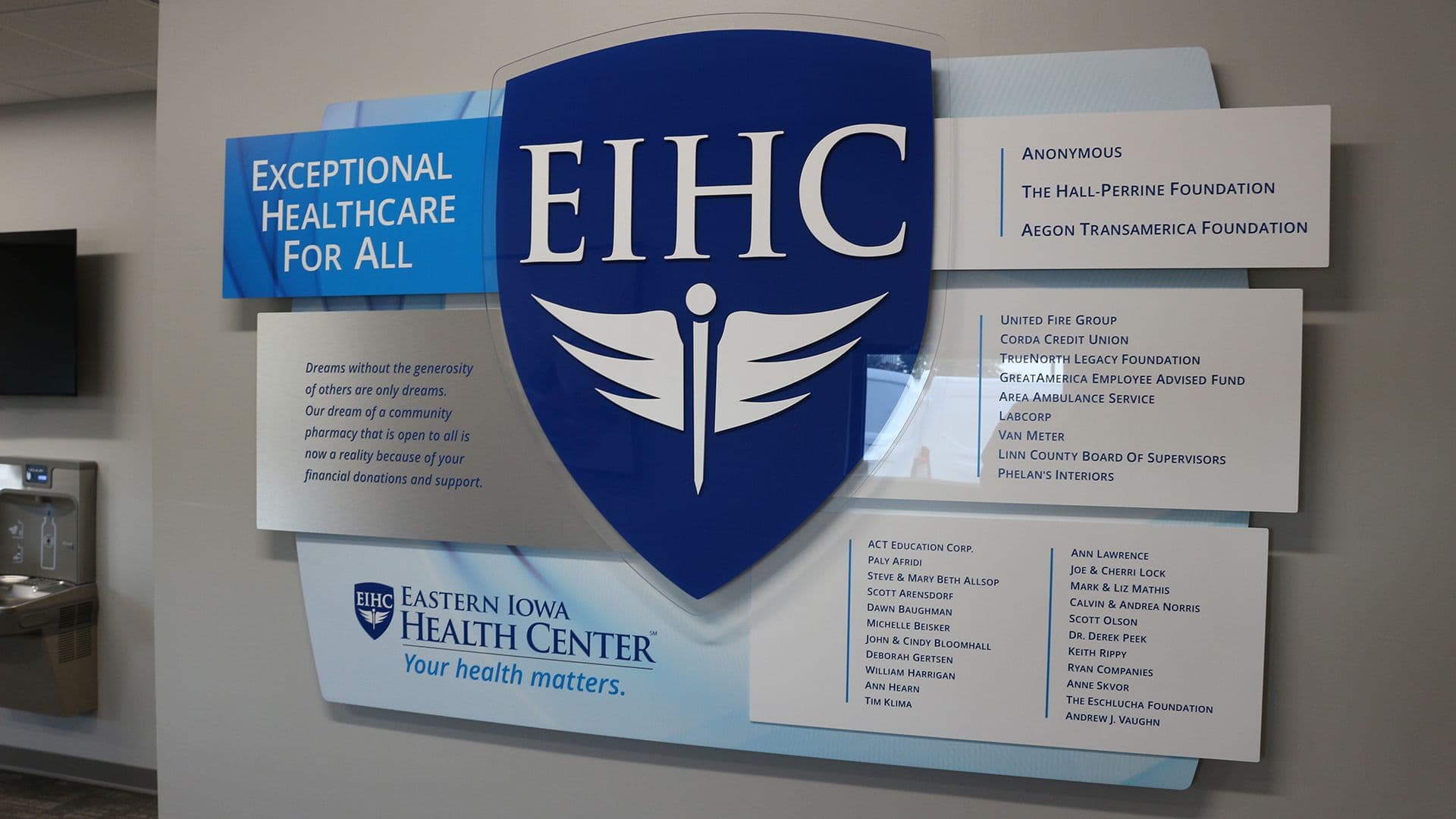 Healthcare donor recognition wall at Eastern Iowa Health Center with layered panels, donor names, and the EIHC emblem supporting access to care.