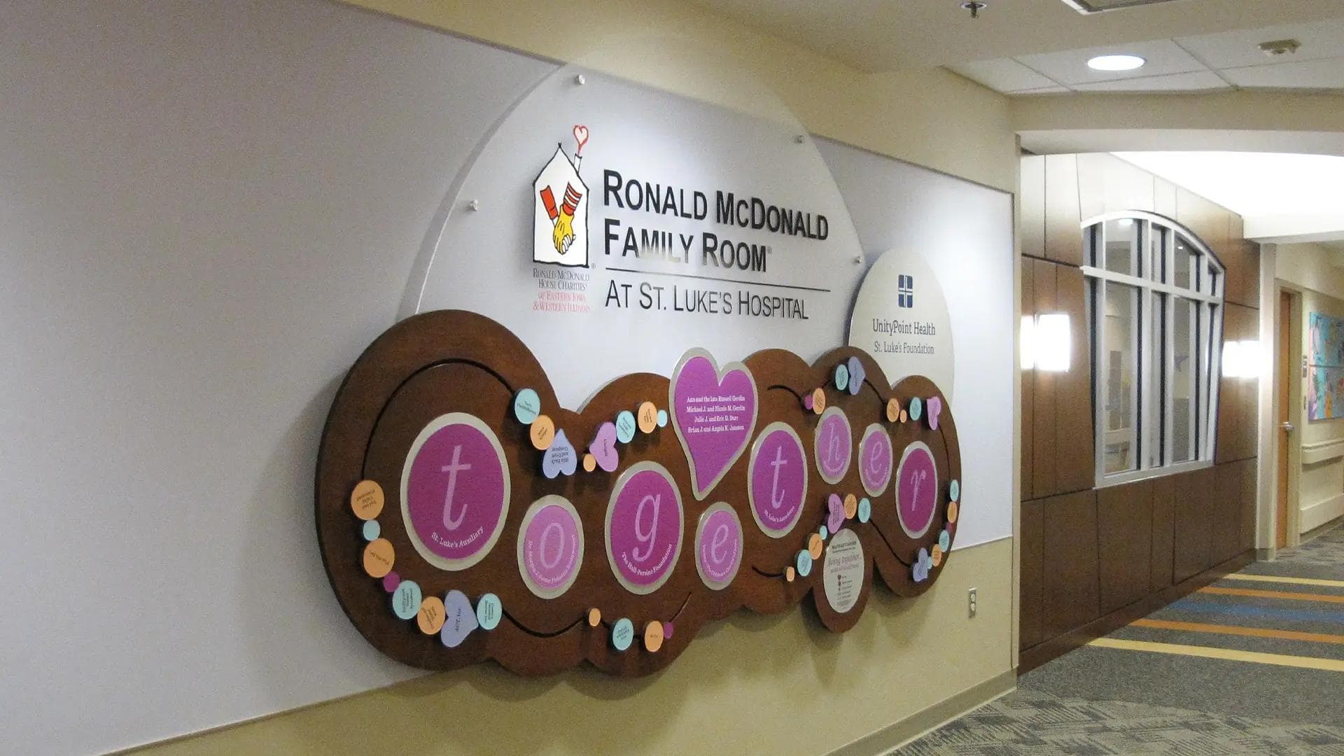 Ronald McDonald Family Room donor wall at St. Luke’s Hospital featuring playful shapes, donor tokens, and child-friendly design.