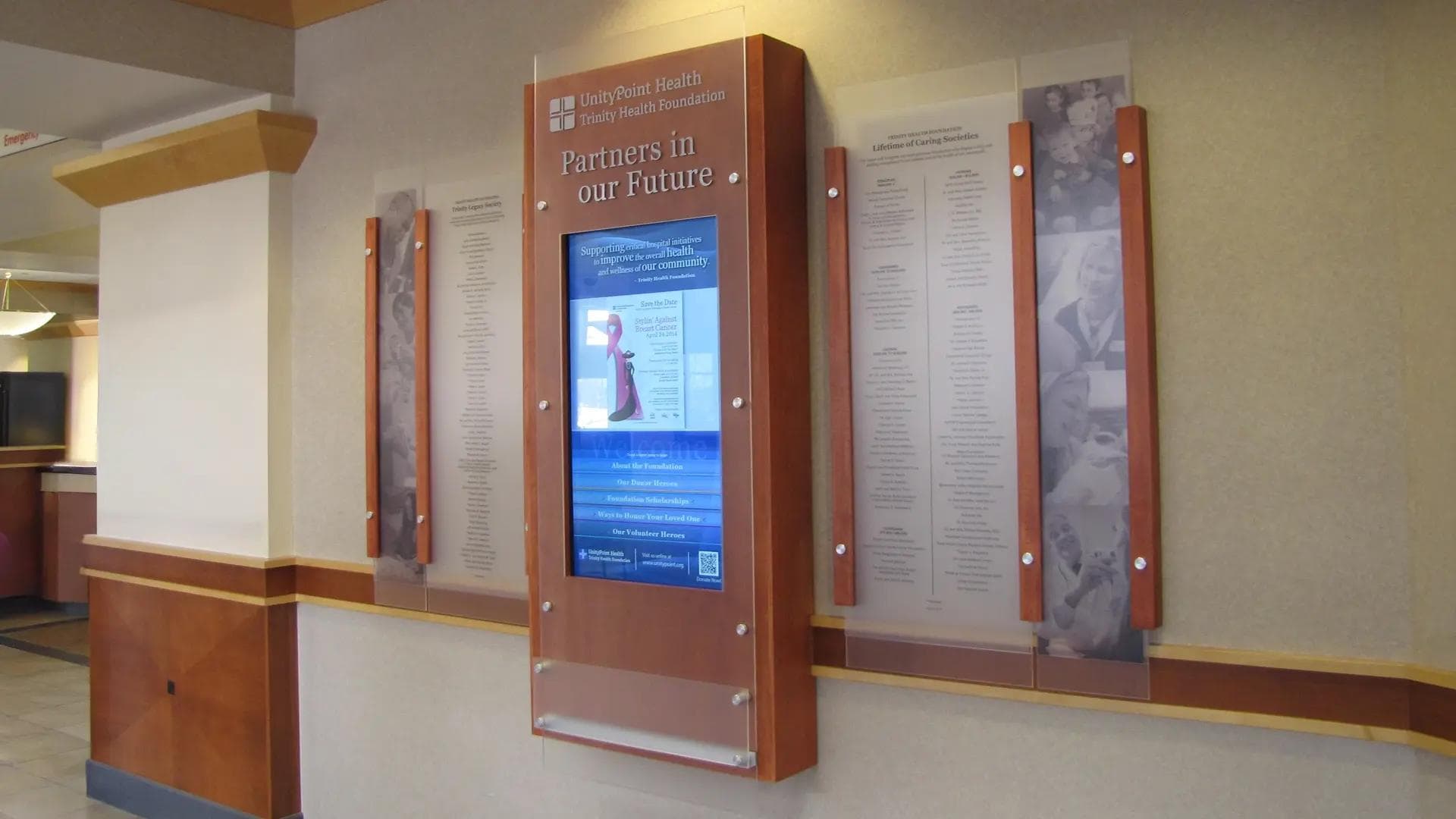 UnityPoint Health hospital network digital donor wall with integrated screen, custom wood surround, and donor panels.