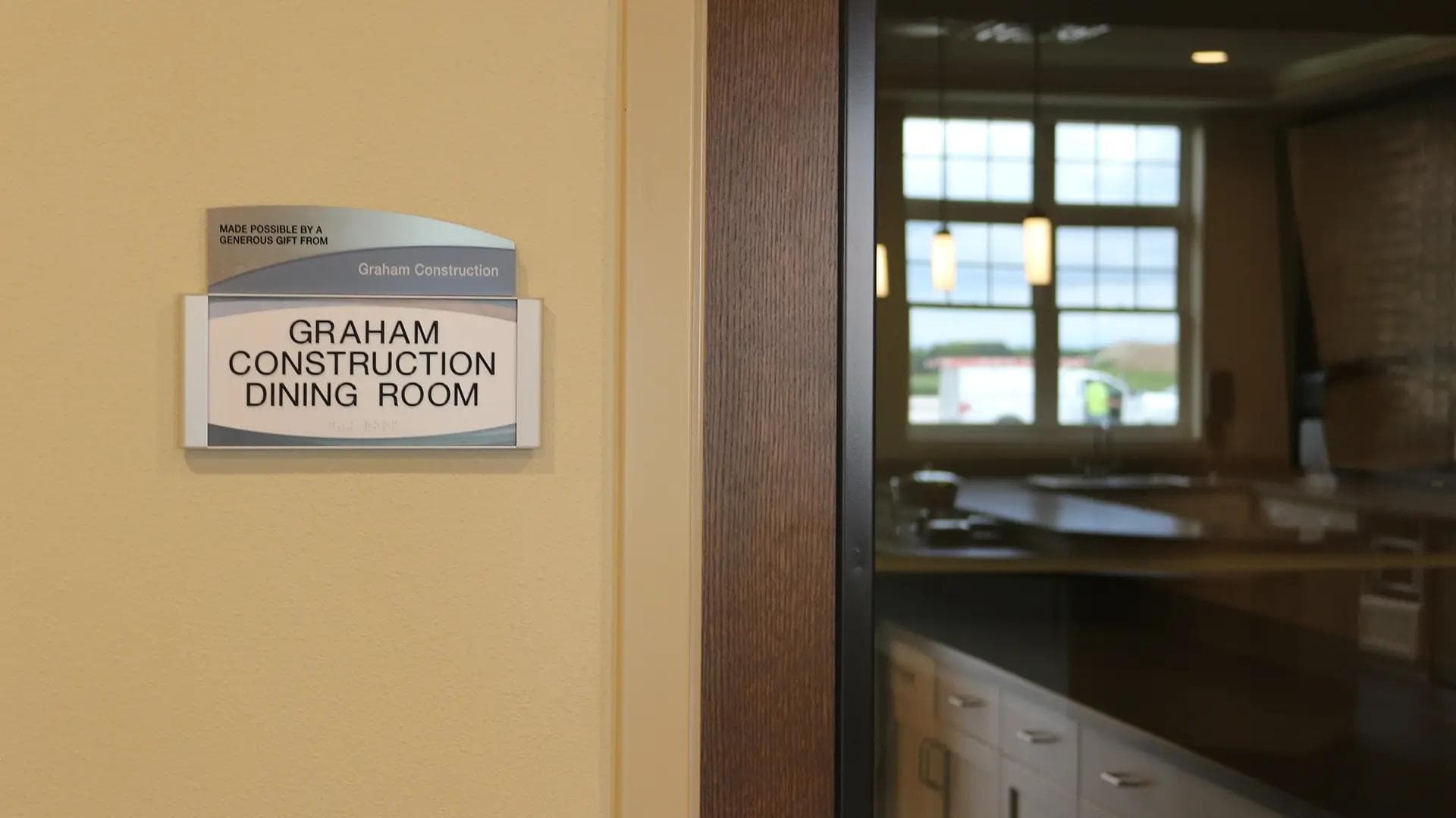 ADA-compliant dining room donor sign providing accessible wayfinding in a transitional healthcare facility.