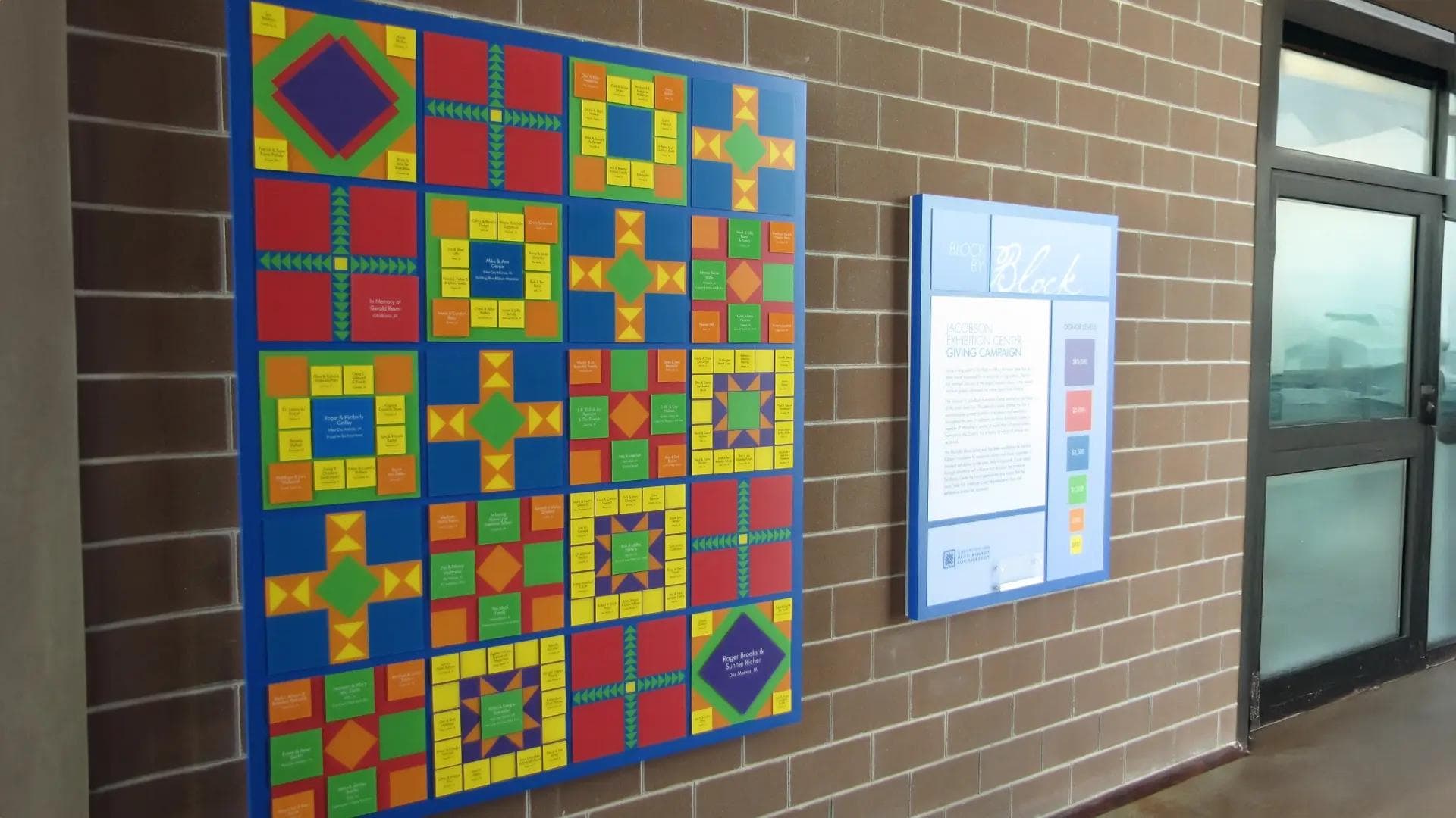 Colorful donor recognition wall with geometric quilt design featuring updateable donor tiles for the Iowa State Fair Blue Ribbon Foundation.