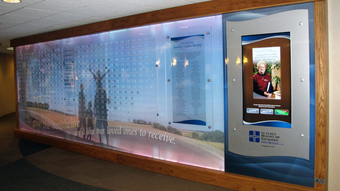 Annual donors and donor stories are on the digital touchscreen. The content is managed through Arreya Digital Signage Suite. The cumulative wall has LED lights that slowly rotate the rainbow of lights behind the acrylic panels.