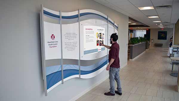 Digital Recognition Donor Wall With Custom Printed Plexiglas Graphics and surround. Interactive Display to read about donors, programs and recognize all donations made to the clinic.